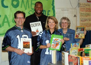 Seattle Seahawks Defensive End Lawrence Jackson surprised Beacon Hill International students with $20,000 worth of new books on Wednesday. L to R: Beacon Hill teacher Andy Pickard, Lawrence Jackson, Librarian Mary Thompson, and Principal Susie Murphy.
