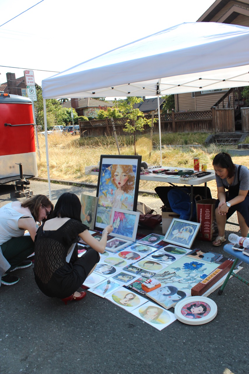 Neighbors checking out the art at a vendor's booth during June's Beacon Art Walkabout. Photo by Wendi Dunlap.